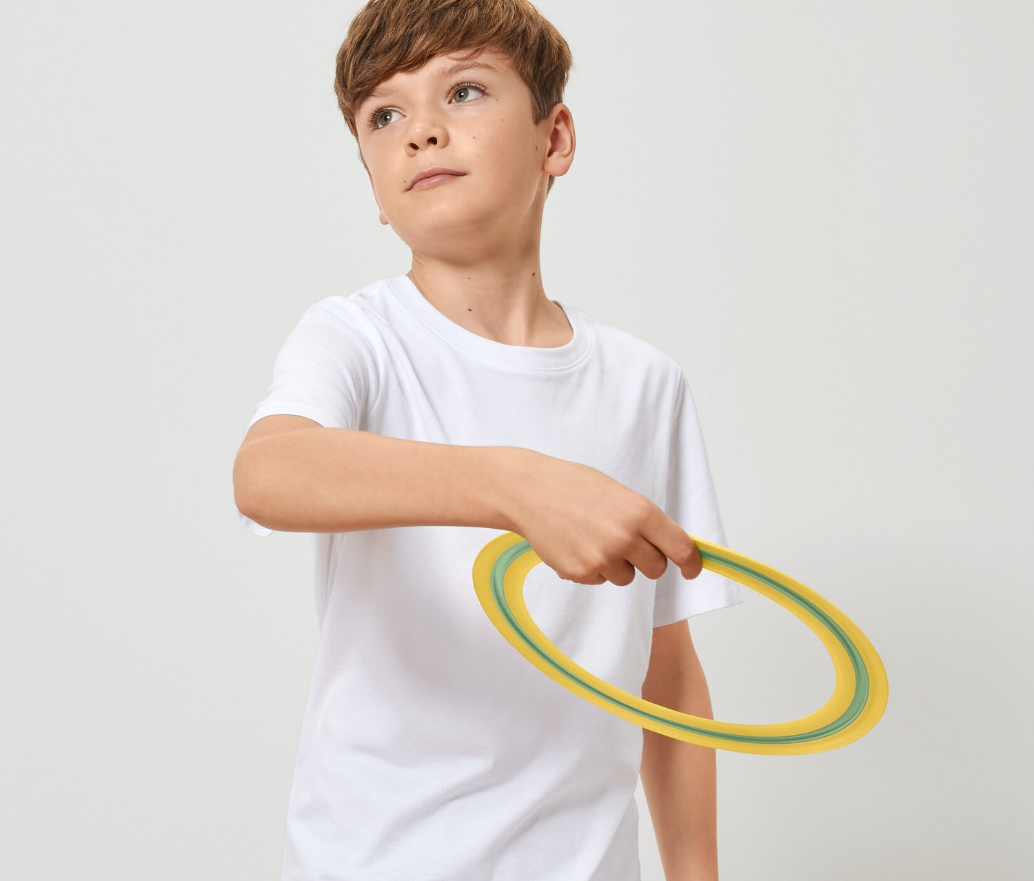 Oğlan elinde bir frizbi tutuyor.