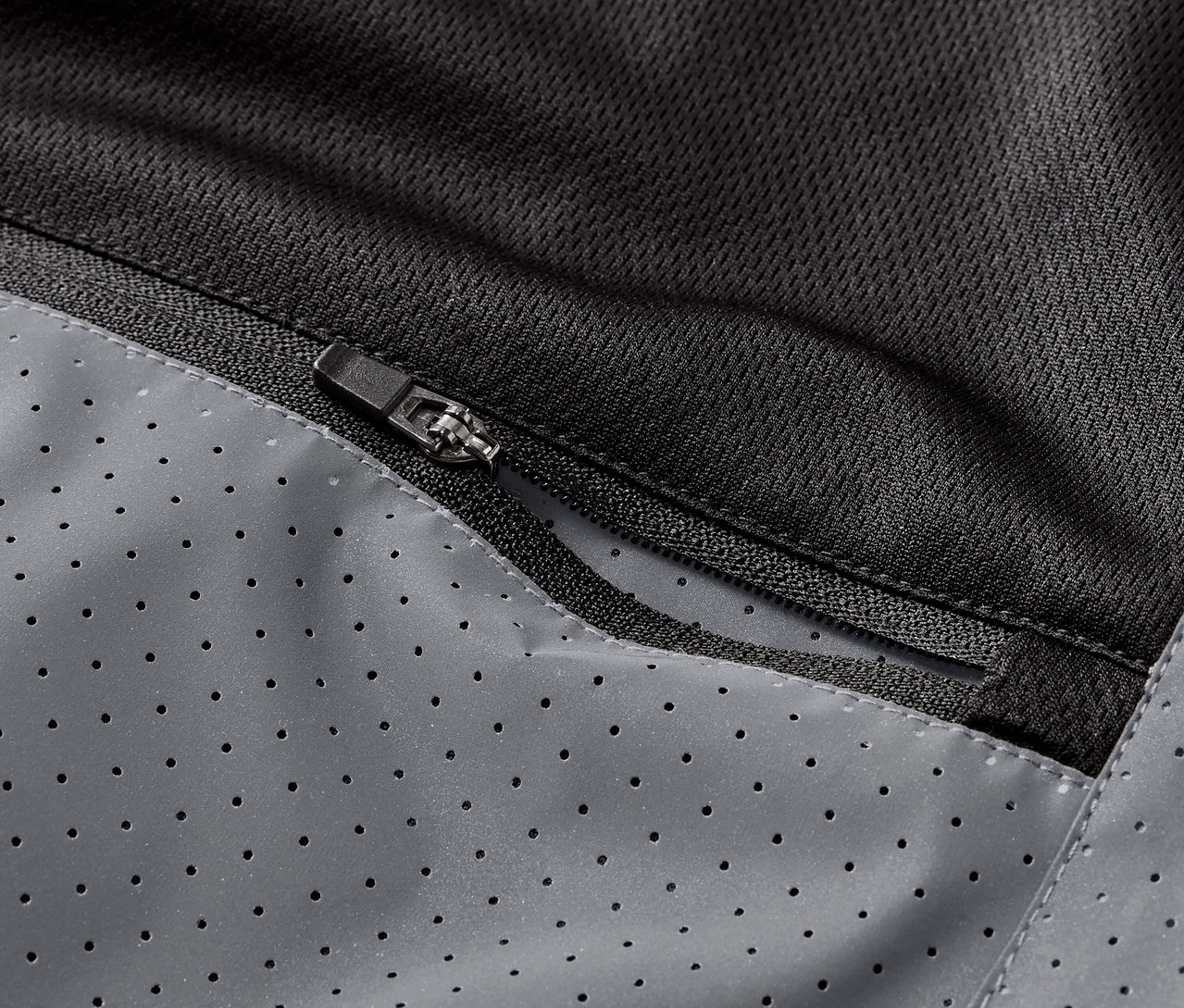 Yansıtıcı bir koşu yeleğinin fermuarlı cebinin yakın çekimi.