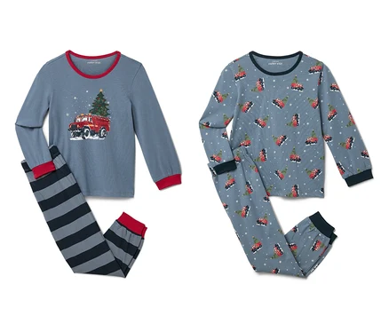 İki çocuk pijaması takımı. Bir takımın üstünde itfaiye aracı ve Noel ağacı baskısı ve çizgili pantolon bulunuyor. Diğer takımın tamamı itfaiye aracı ve Noel ağacı baskılı.
