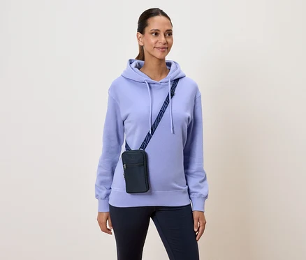 Kadın açık mor kapüşonlu sweatshirt ve lacivert omuz çantası takıyor.