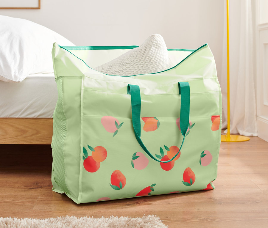 Şeftali desenli jumbo nevresim çantası, bir yatağın yanındaki zeminde duruyor.