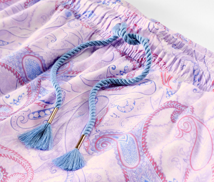 Paisley desenli ve mavi büzgülü mor pijama altının yakın çekimi.