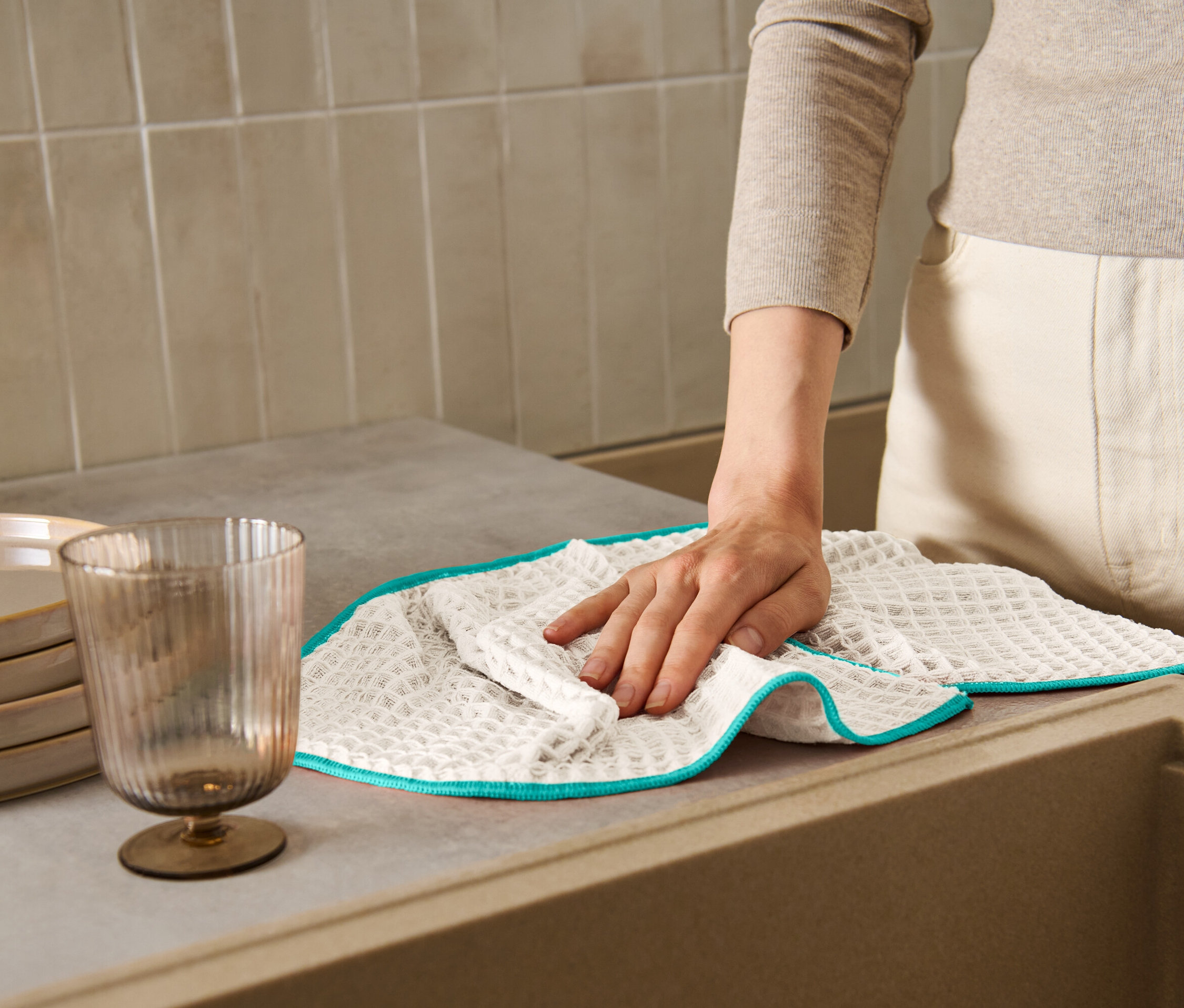 Kadın tezgahı ekstra büyük kurulama beziyle siliyor.