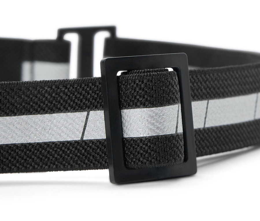 Siyah elastik bant ve gümüş reflektörlü şeride sahip kompakt bir kafa lambasının yakın çekim görüntüsü.