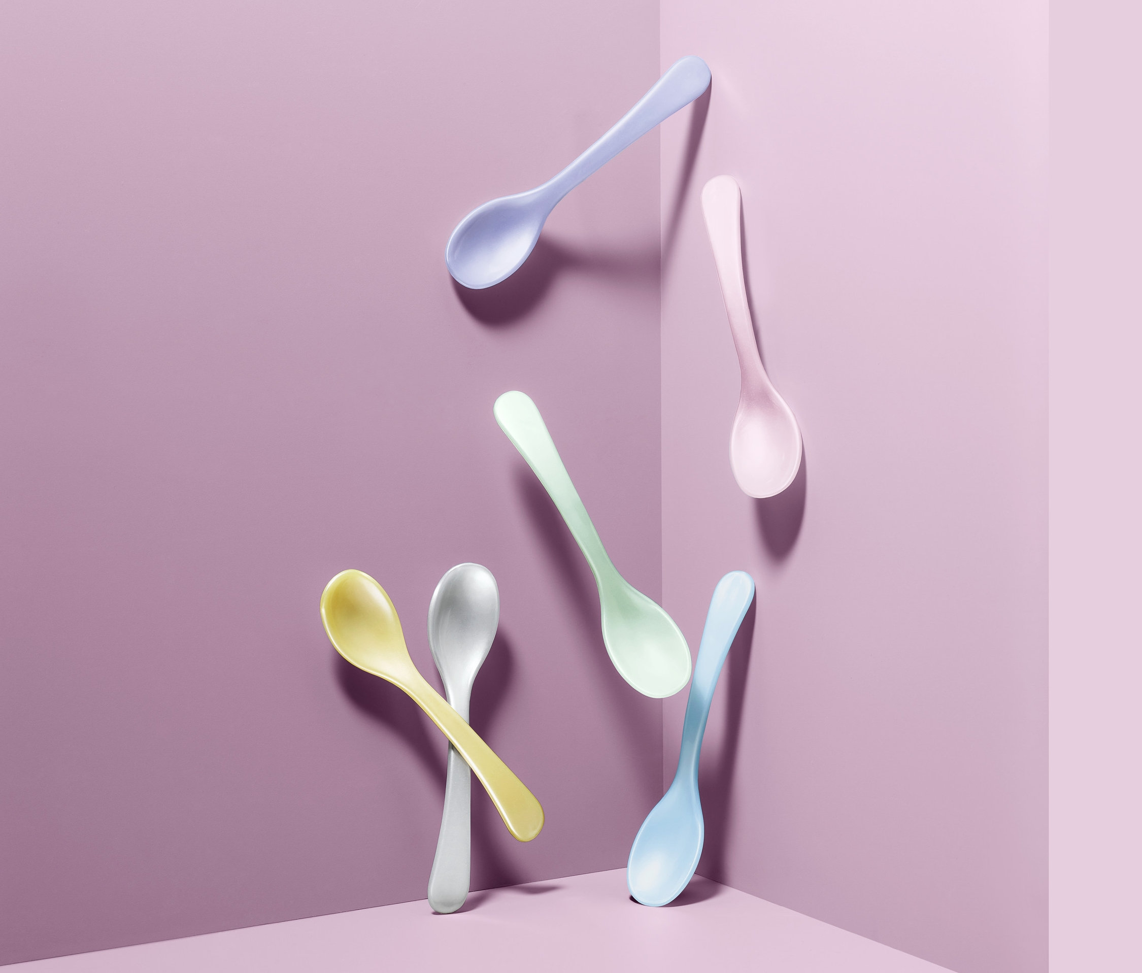 Mor arka planda altı adet renkli yumurta kaşığı.