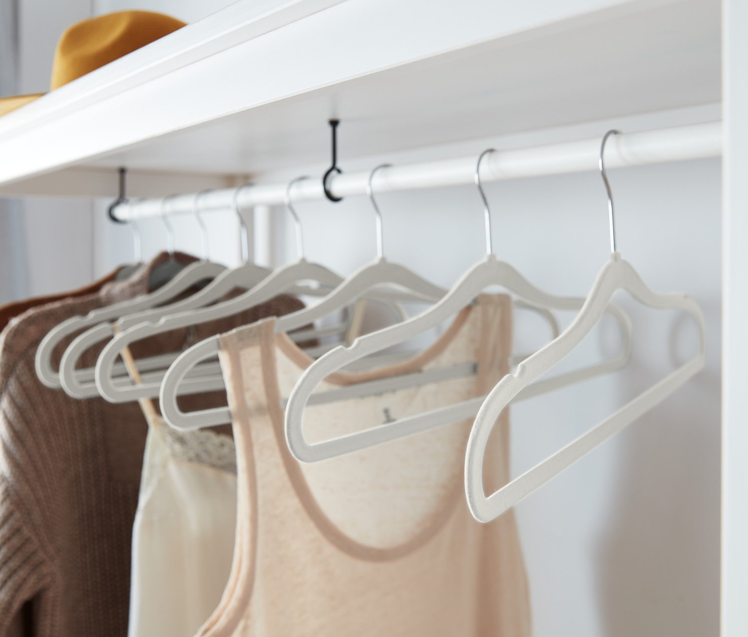 Giysiler sekiz adet gri, ekstra ince elbise askısında asılı duruyor.