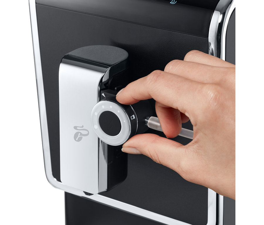 Bir el, antrasit renkli »Esperto Pro« Tchibo Tam Otomatik Kahve Makinesini ayarlıyor.