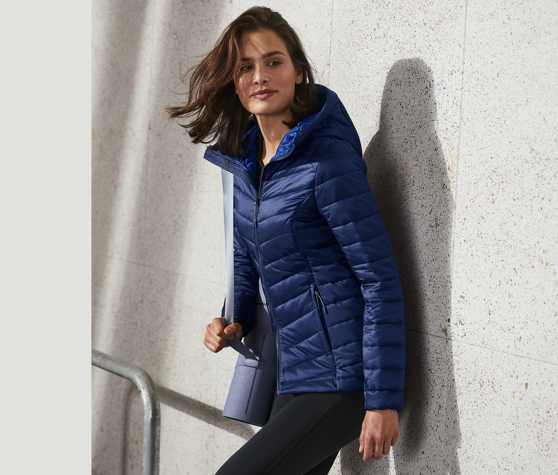 Kadın mavi hafif kapitone montla yürüyor.