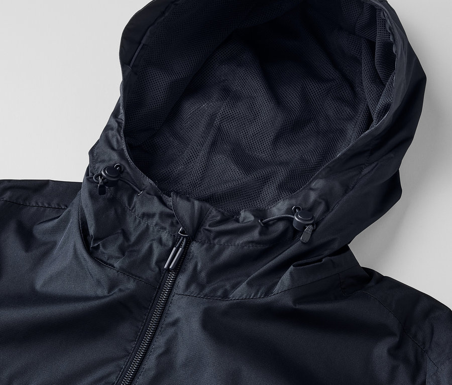 Kapüşonlu ve fermuarlı siyah unisex yağmurluk detayı.