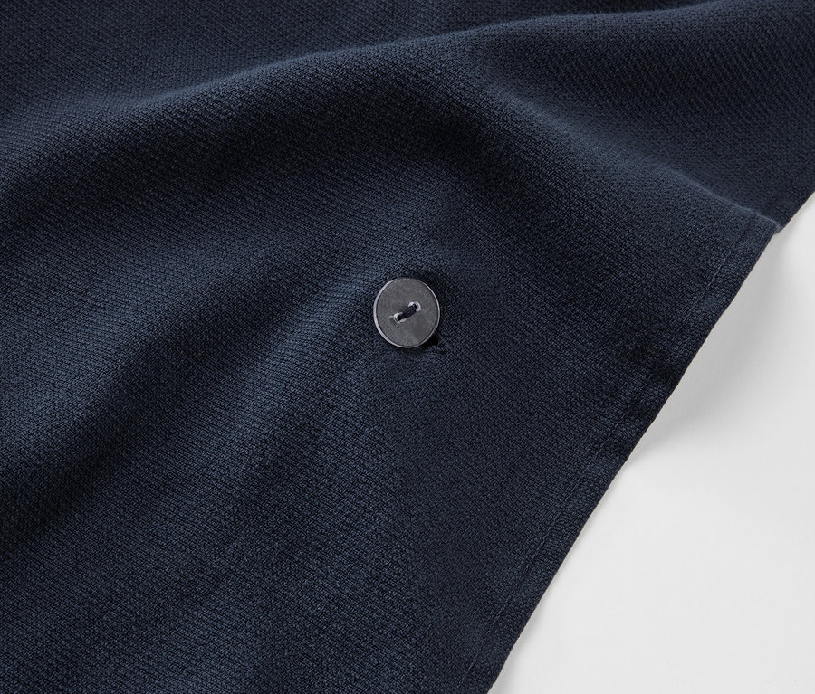 Düğmeli, lacivert renkli 2'si 1 arada banyo havlusu ve panço detayı.