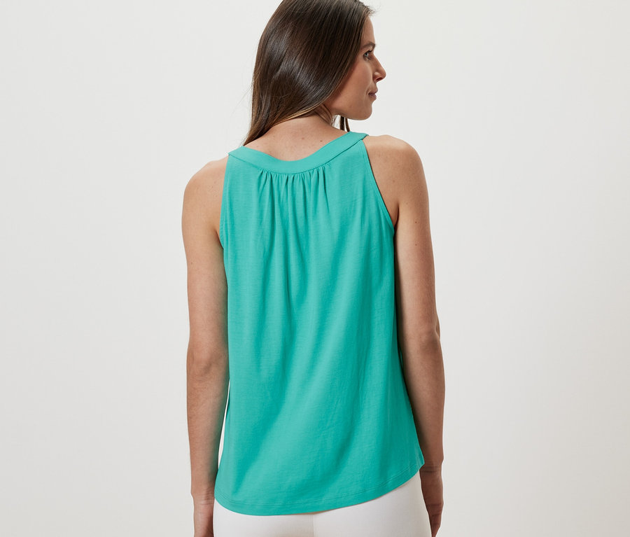 Kadın, Deniz Mavisi bir üst giyiyor.