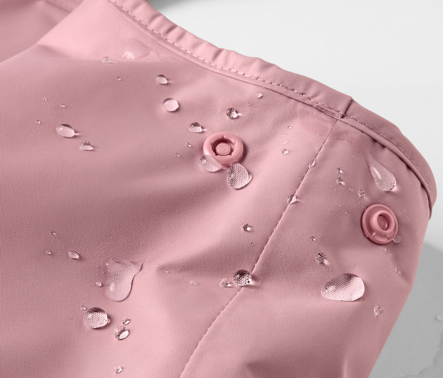 Su damlaları olan pembe çocuk termo yağmurluk detay görünümü.