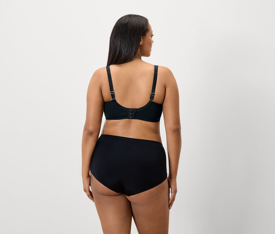 Siyah sütyen ve külotlu, koyu renk saçlı bir kadının arkadan görünümü.