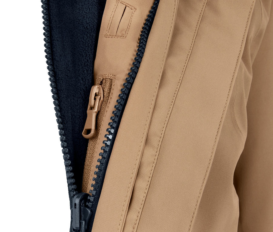 Açık fermuarlı ve lacivert iç katmanlı bej renkli 3'ü 1 arada fonksiyonel bir dış mekan paltosunun yakın çekimi.