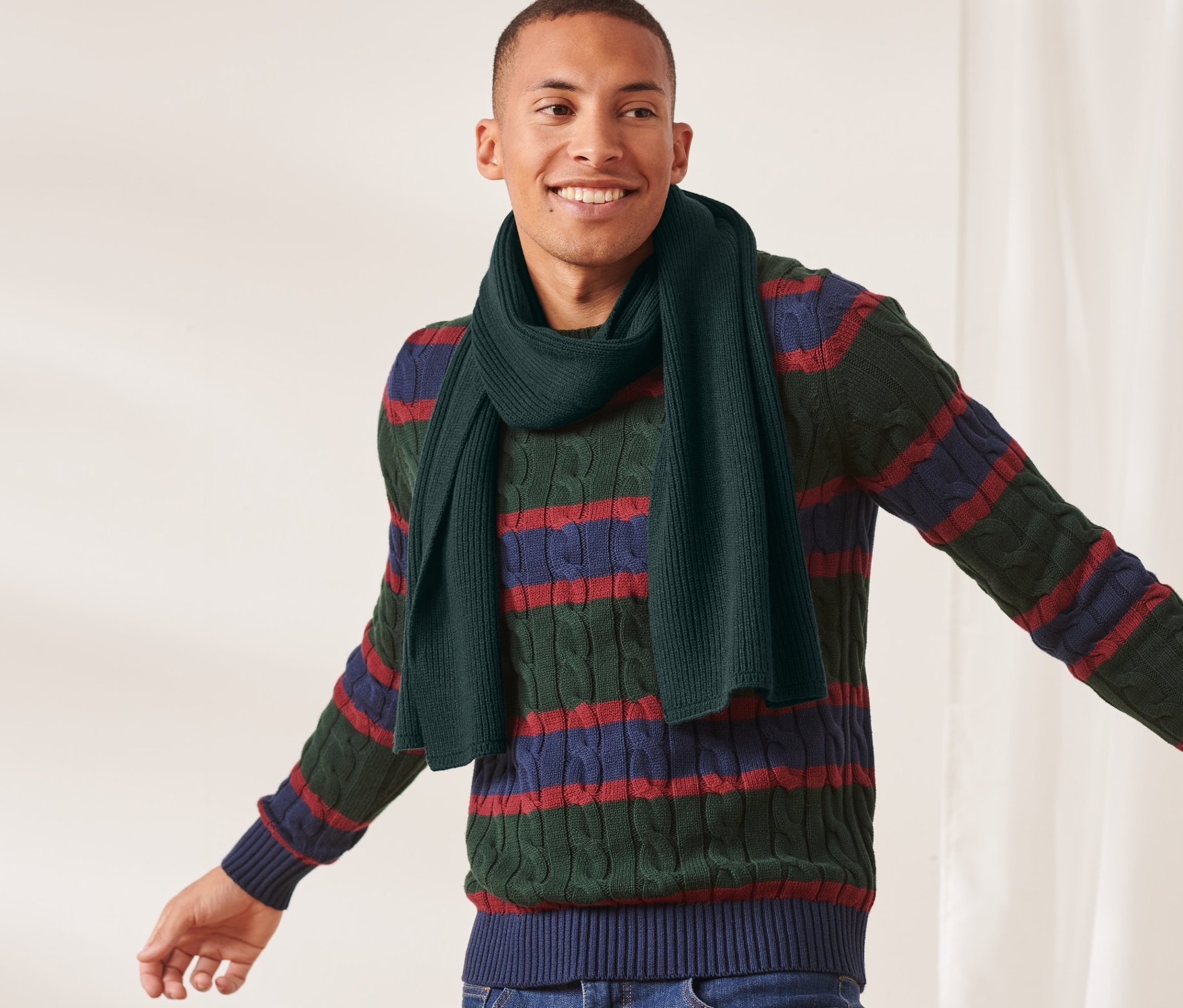 Adam koyu yeşil örgü atkı takıyor.