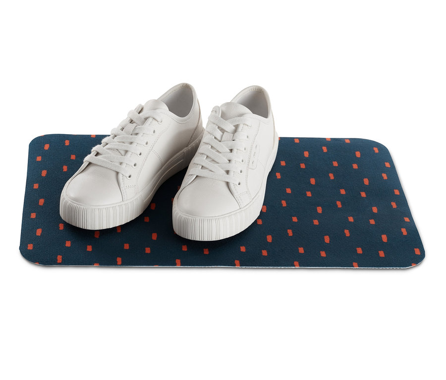 Turuncu kareli, lacivert Polar Mama Kabı Altlığı üzerinde iki beyaz spor ayakkabı.