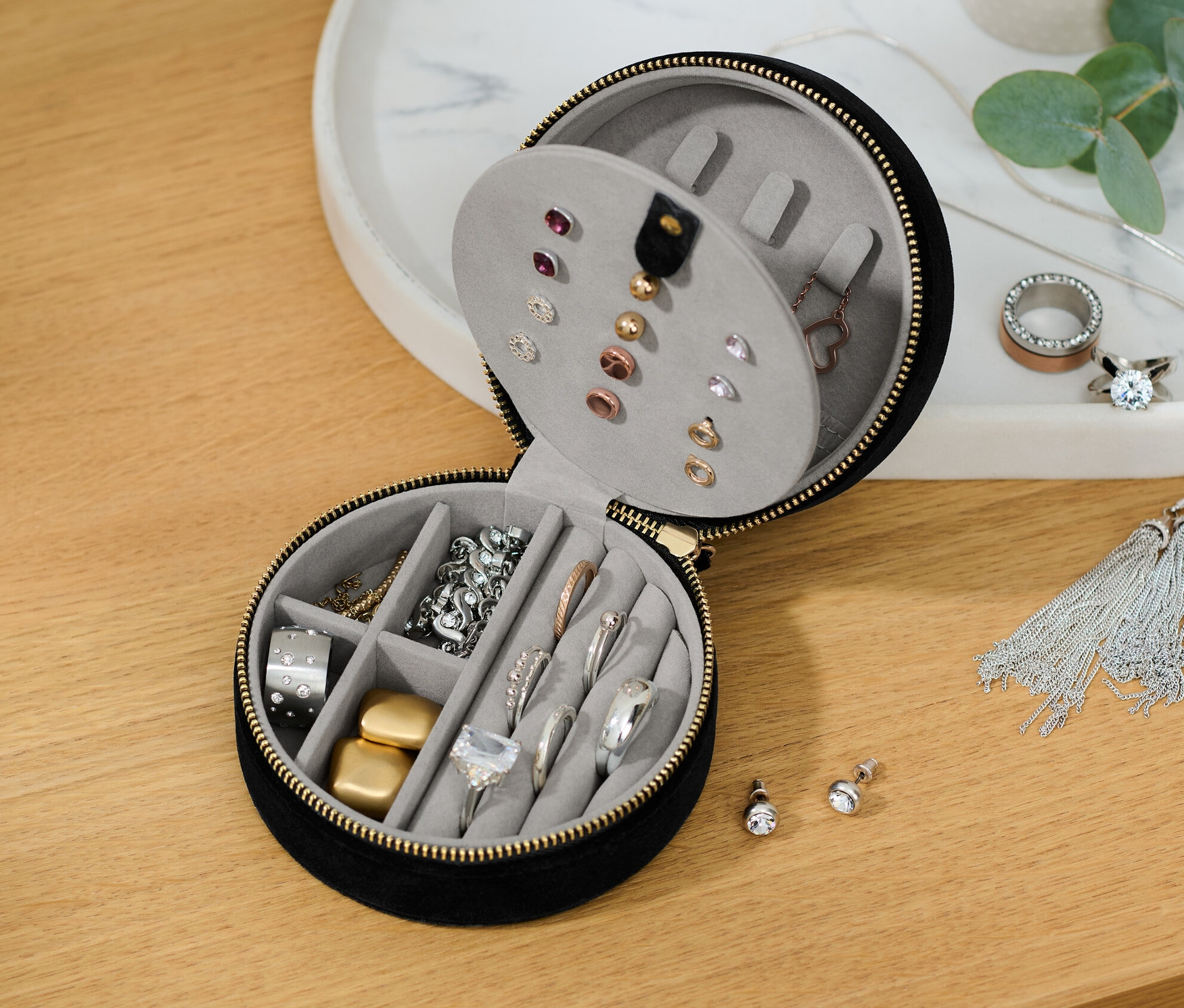 İçinde çeşitli takılar bulunan, kısmen açık küçük bir takı kutusu.