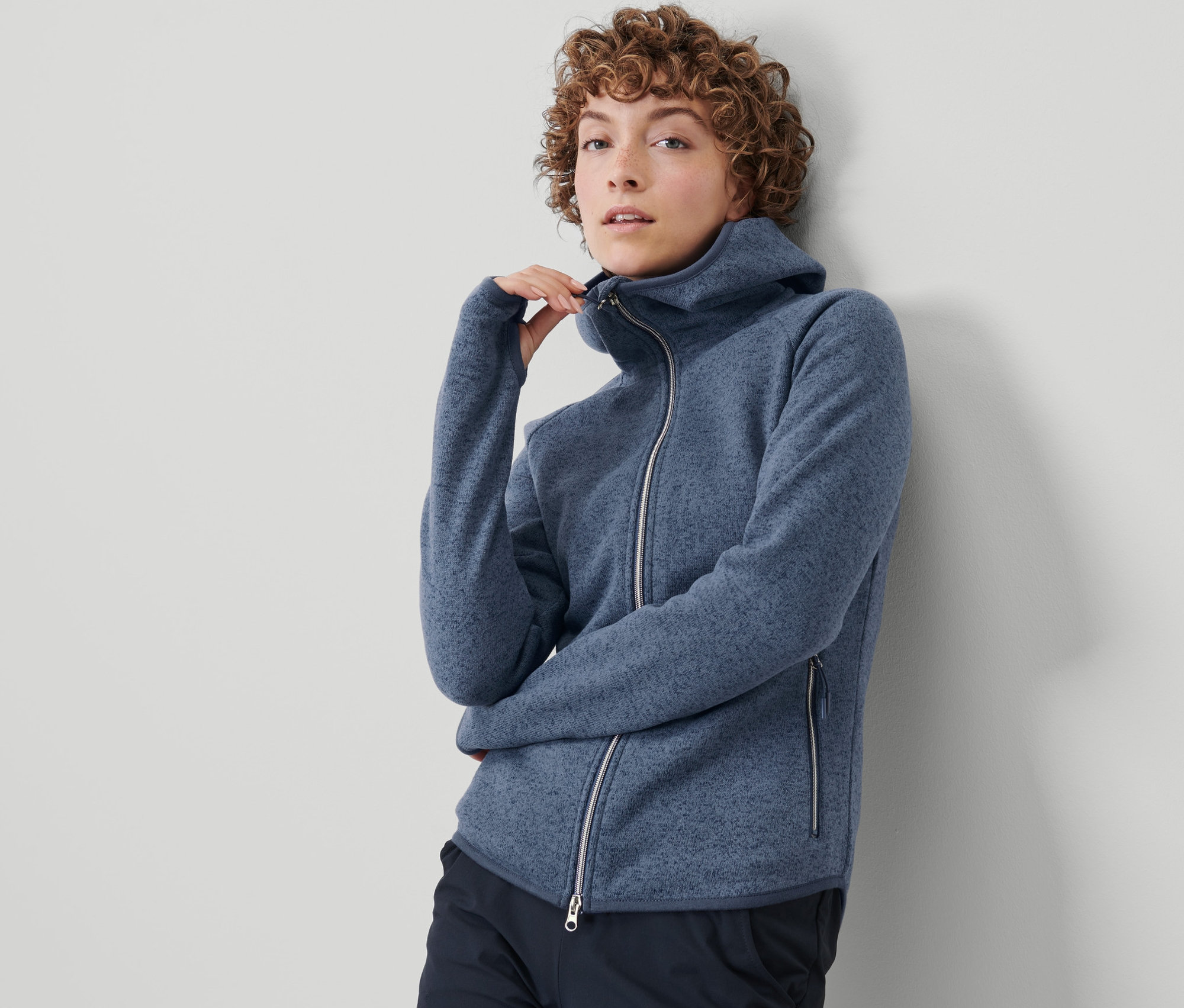 Kadın örgü polar ceketini kapatıyor.