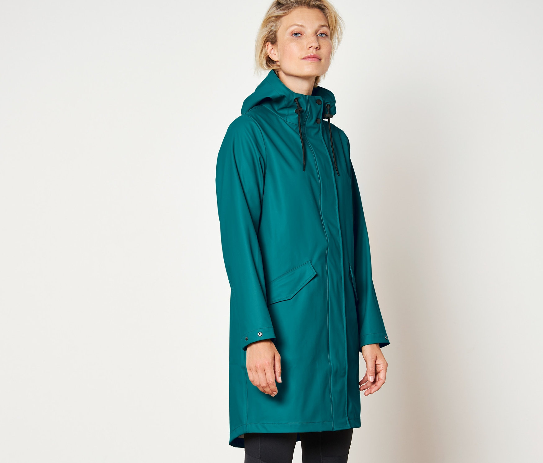 Kadın bir yağmurluk giyiyor