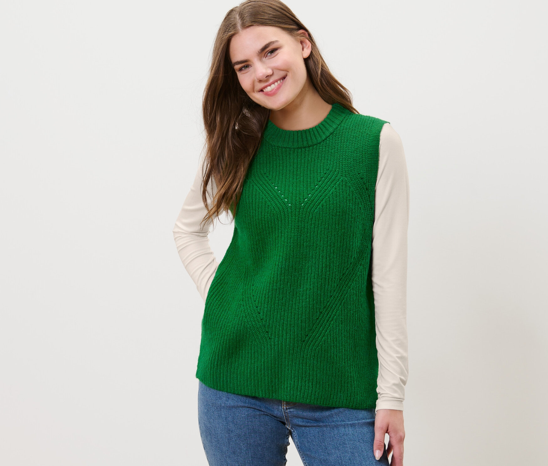 Kadın yeşil örgü süveter giyiyor.