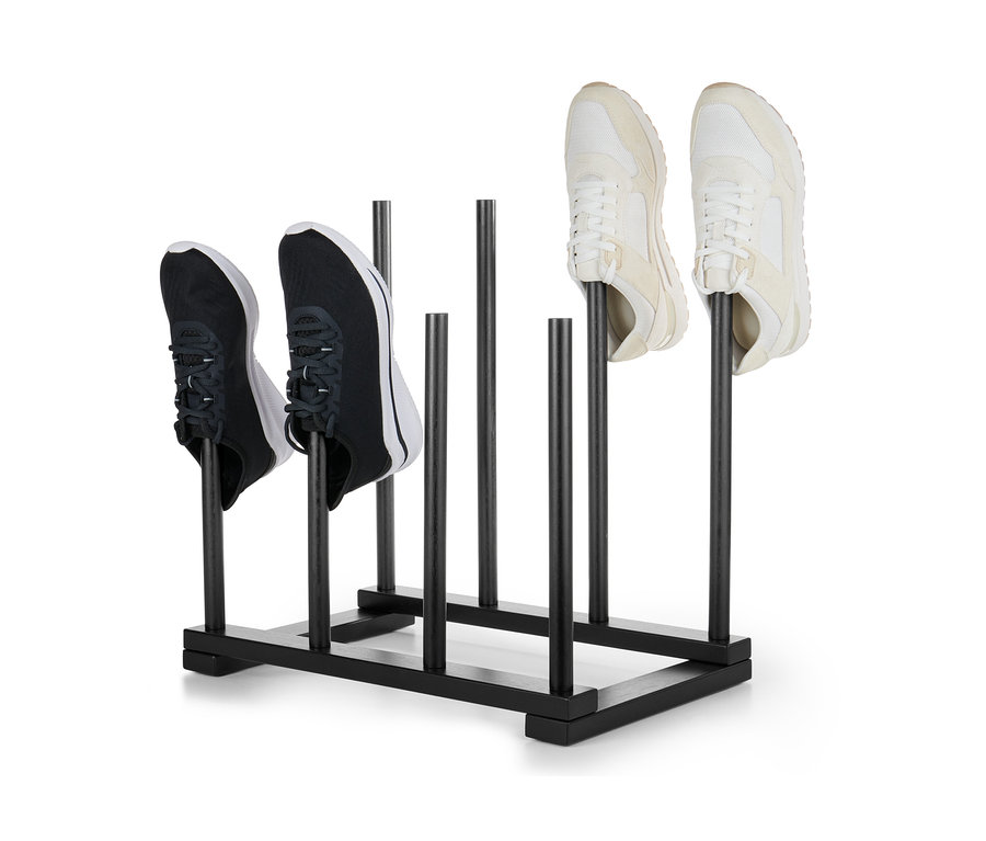 Siyah bir çizme askısında duran iki çift ayakkabı.