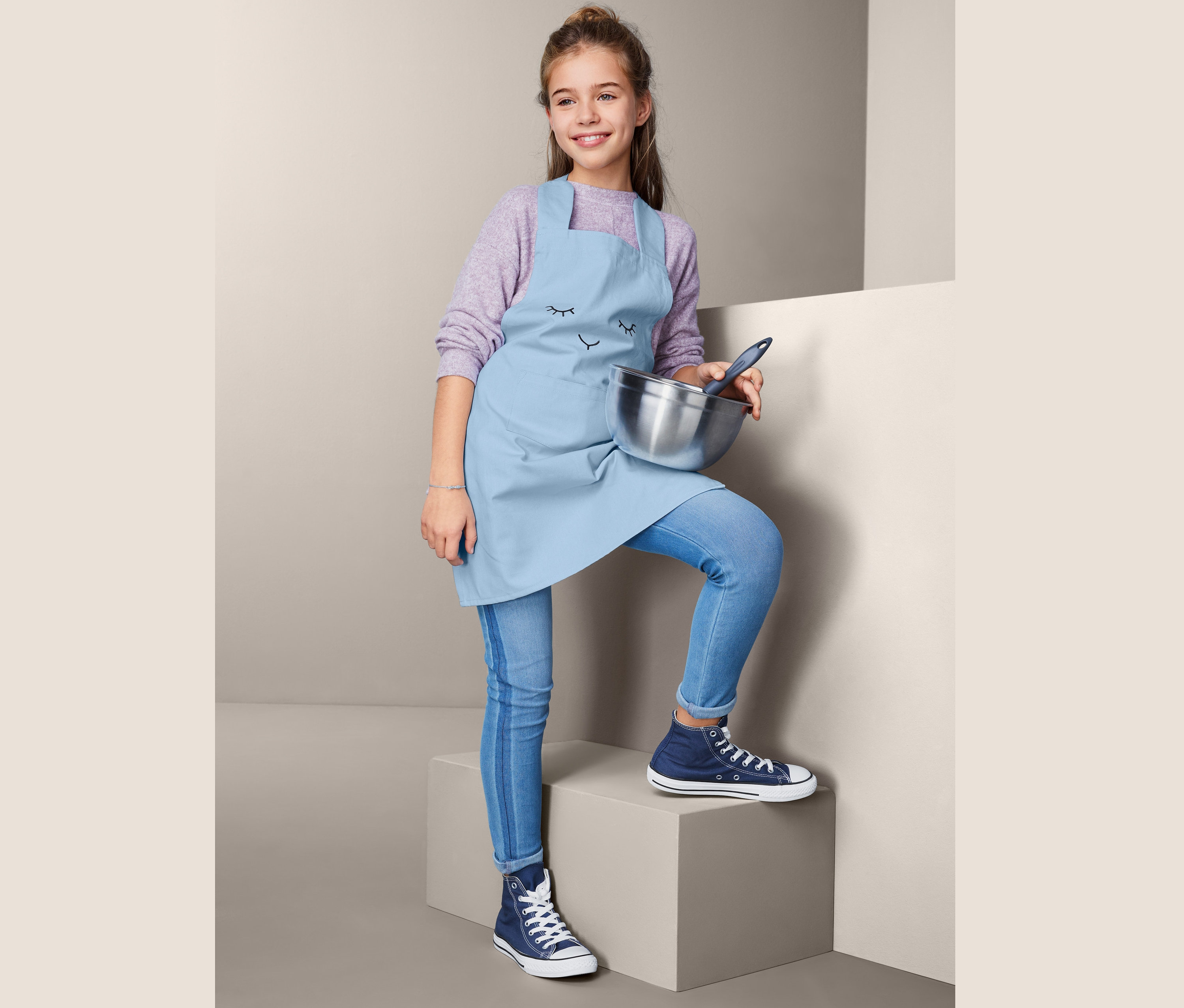 Çocuk mutfak önlüklü kız çocuğu kase tutuyor.