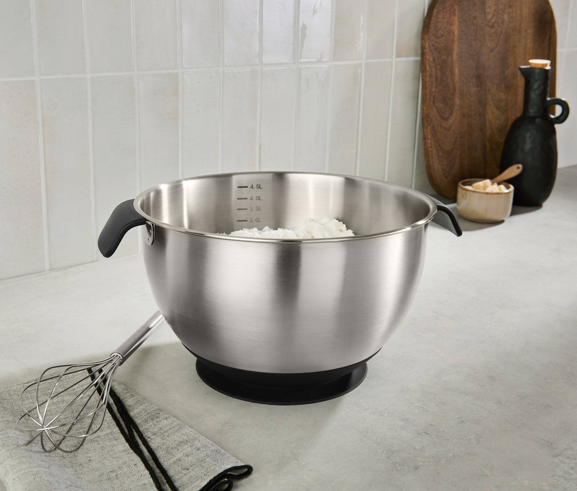 Tezgahta paslanmaz çelik karıştırma kabı ve içinde malzeme bulunuyor.