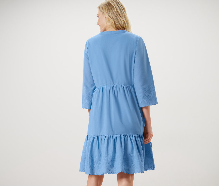 Kadın nakışlı dokuma elbise giyiyor.