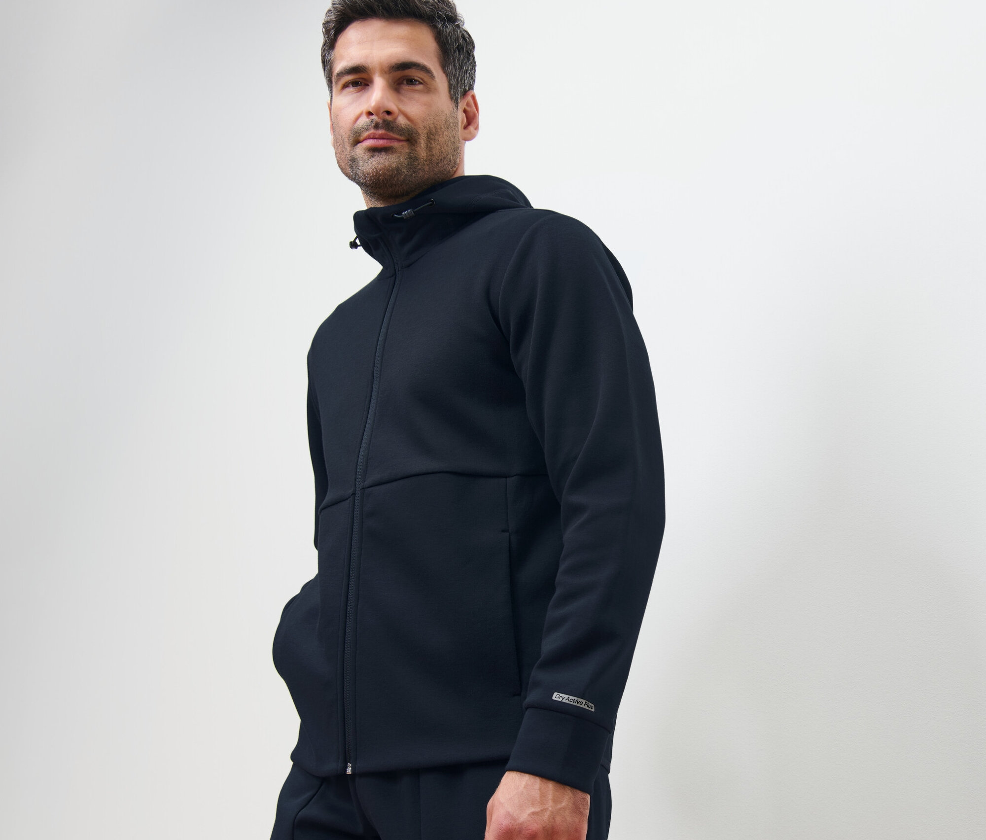 Adam koyu lacivert Fonksiyonel Sweat Ceket ile poz veriyor.