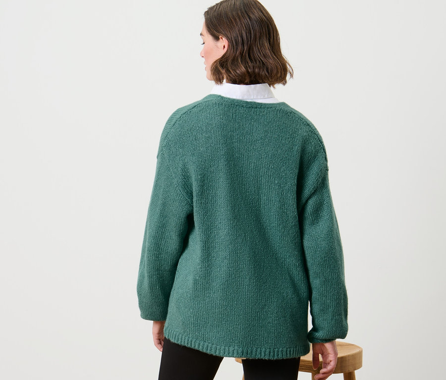 Kadın Kalın Örgülü Hırka giyiyor.