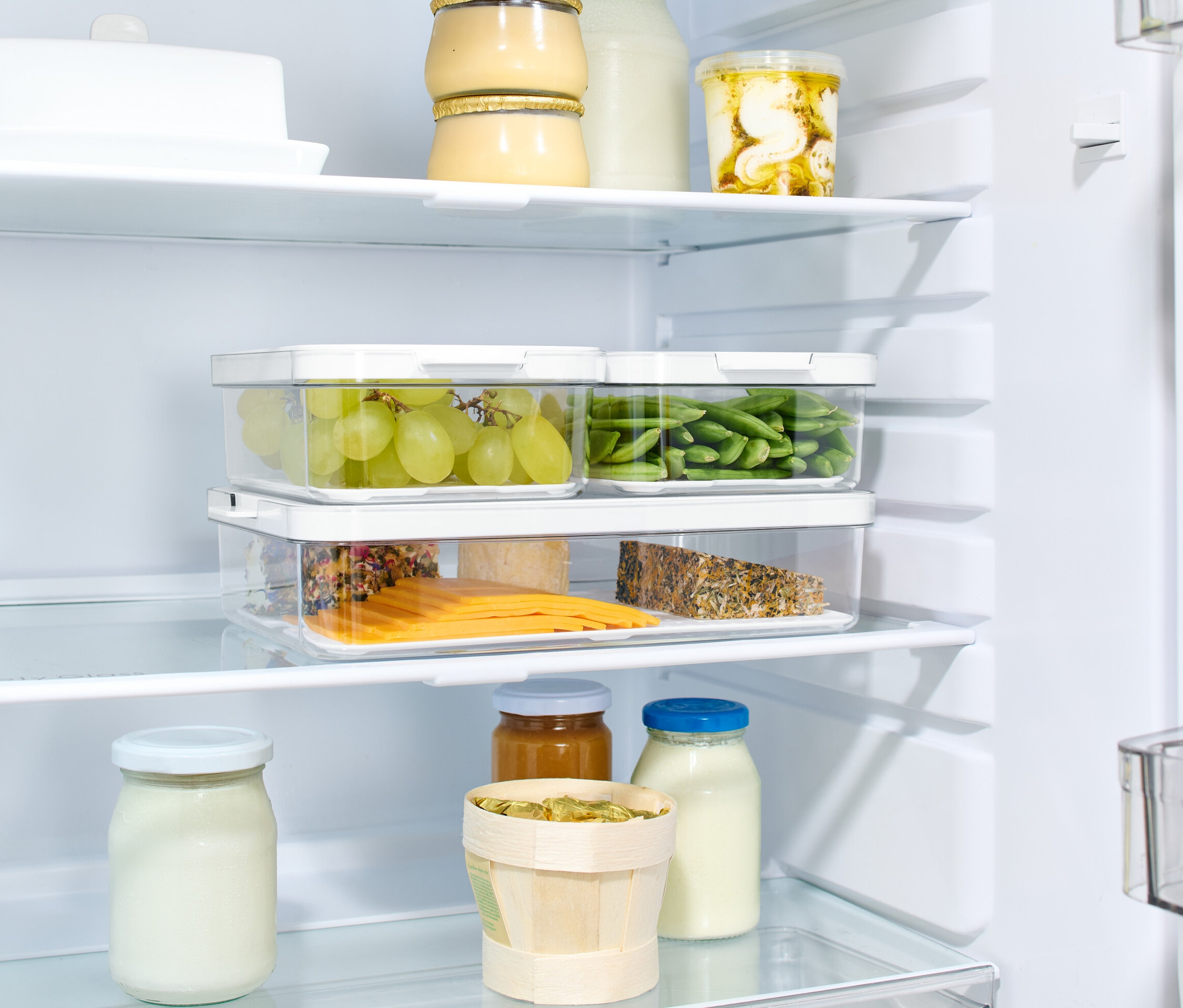 Buzdolabında kapaklı 3 adet saklama kutusu bulunmaktadır. Kutuların içinde yeşil üzüm, yeşil fasulye ve peynir dilimleri bulunmaktadır.