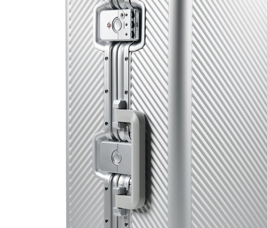 Kilit ve sapı olan alüminyum bavulun detayı.