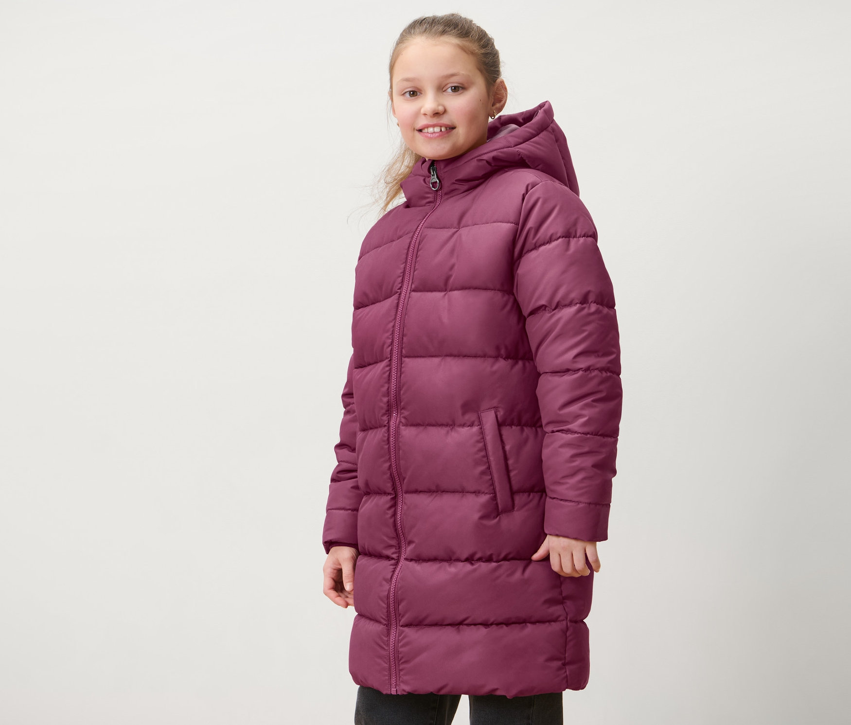 Kız çocuğu kırmızı menekşe rengi termal palto giyiyor.