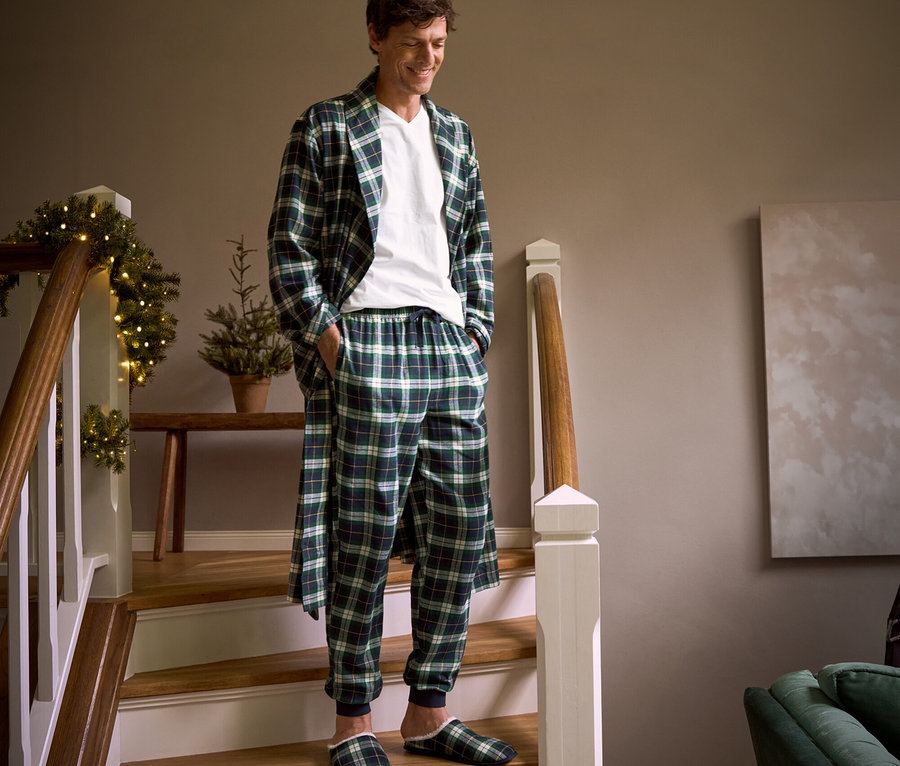 Merdivenlerden inen bir adam; üzerinde ekoseli flanel sabahlık, rahat flanel pantolon, ev terliği ve 2 adet V yaka tişört var