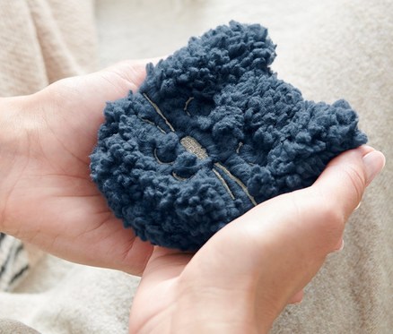 Bir kişi elinde iki adet »Kedi« cep ısıtıcısı tutuyor.