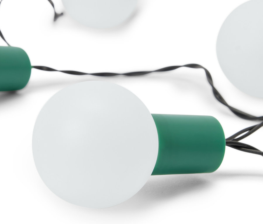 Beyaz bir arka plan üzerinde beyaz ampulleri ve yeşil duy başlıkları olan bir LED Işık Zinciri yakın çekimi.