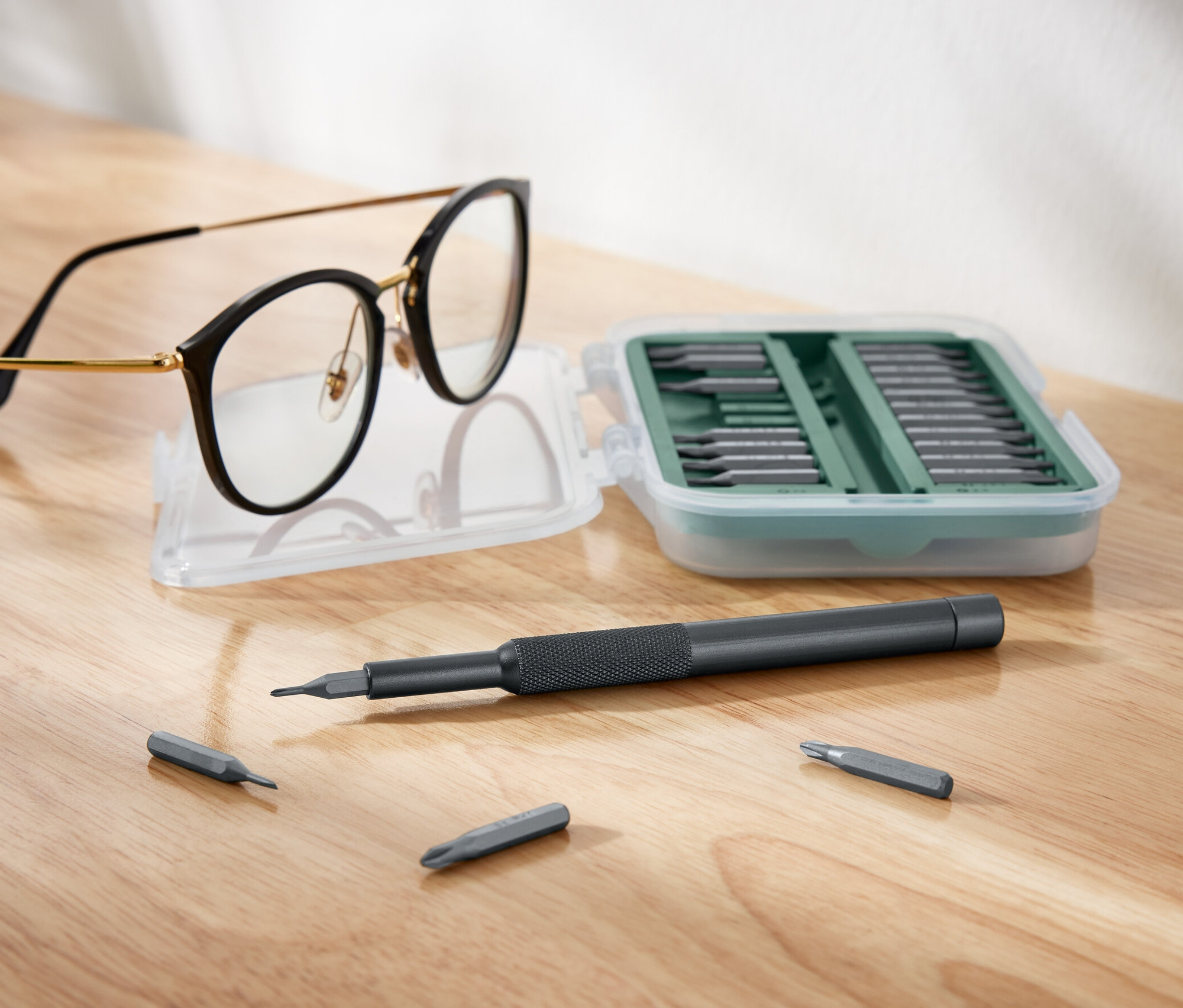 Gözlükler açık bir hassas tornavida setinin yanında duruyor.