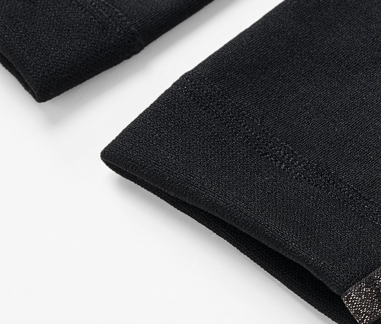 Beyaz bir arka plan üzerinde iki siyah kol ısıtıcısının detayı.