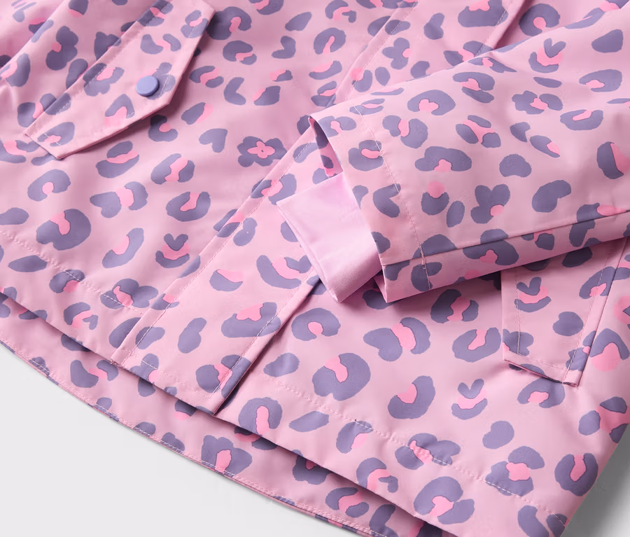 Pembe ve mor leopar desenli, cepli ve düğmeli bir ceketin yakın çekimi.