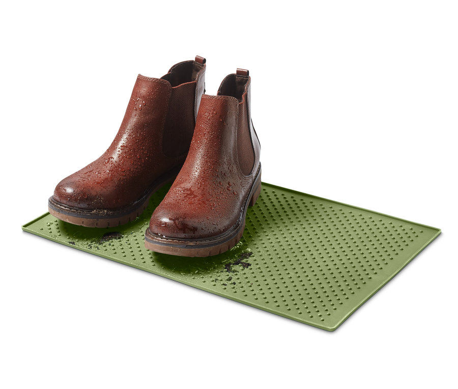 Yeşil mama kabı altlığının üzerinde duran iki kahverengi bot.