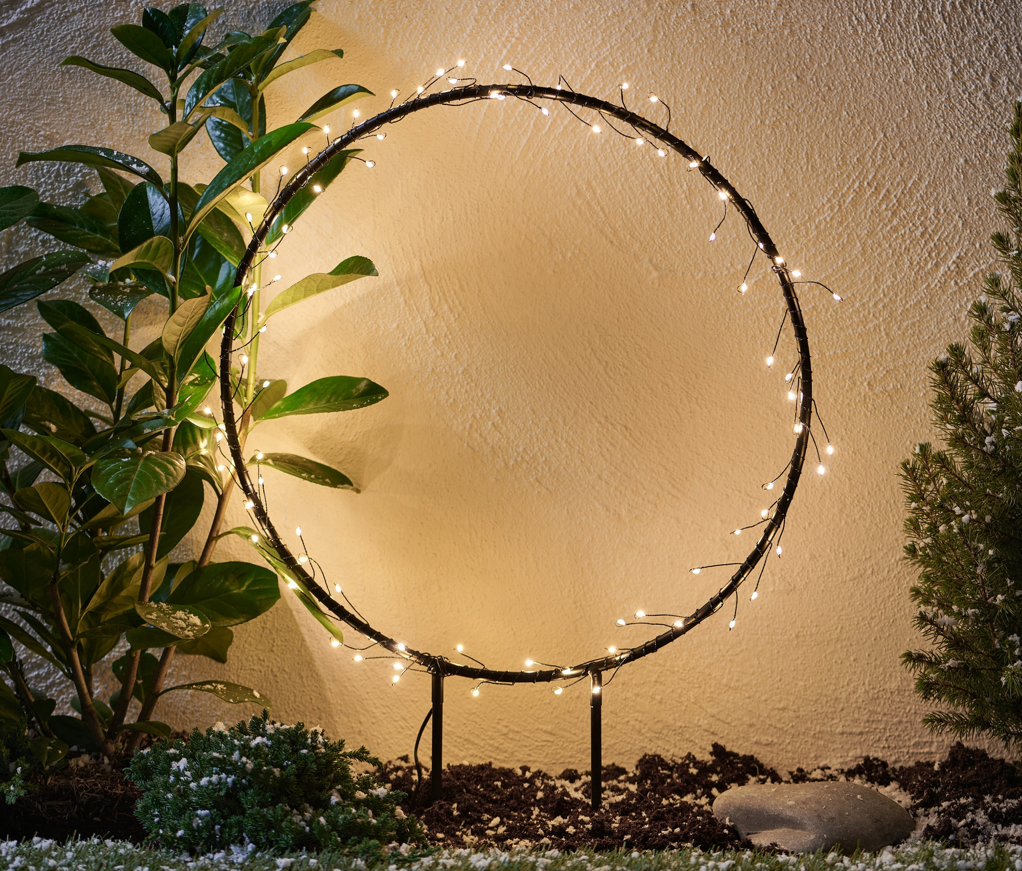 Metal LED Outdoor Halka bitkilerin arasında duruyor.