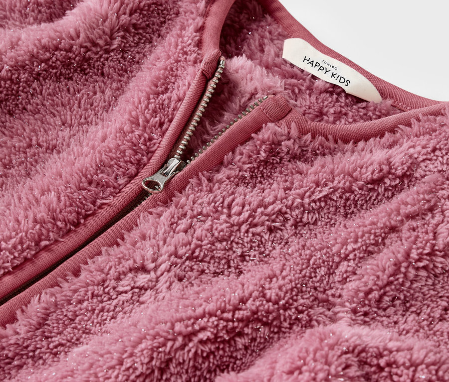 Açık fermuarlı pembe, tüylü bir ceketin detaylı görüntüsü.