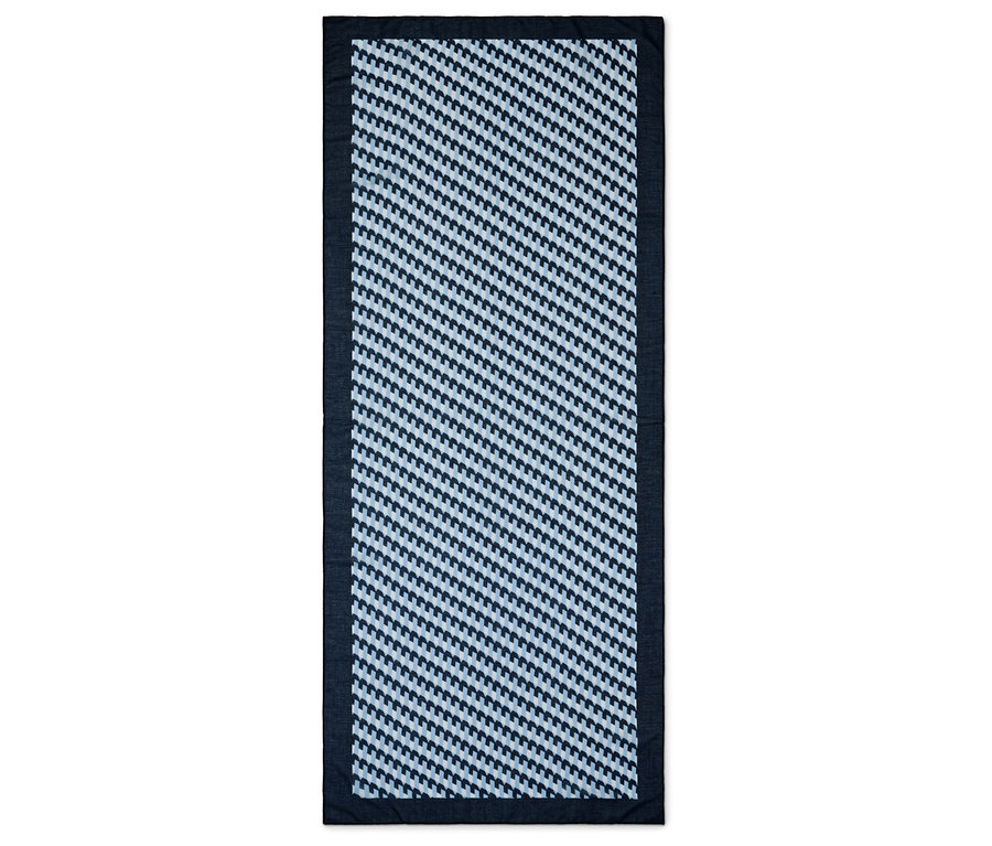 Lacivert kenarlıklı, mavi ve beyaz geometrik desenli dikdörtgen halı.