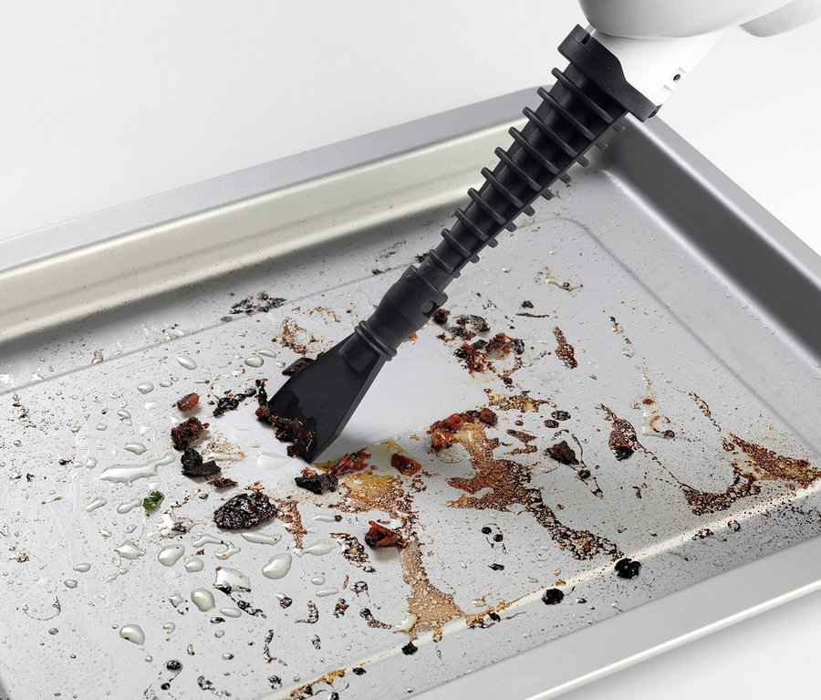 Çok fonksiyonlu buharlı paspas, bir fırın tepsisini yemek artıklarından temizliyor.