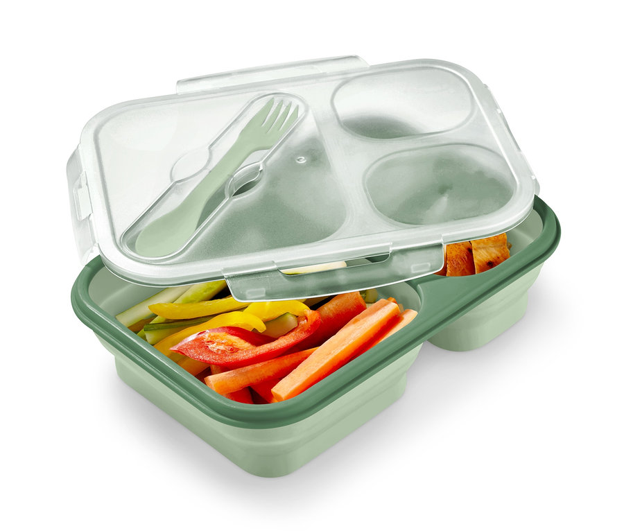 Doğranmış sebzeler ve çatal bıçak takımı içeren yeşil, katlanabilir bir yemek kutusu.