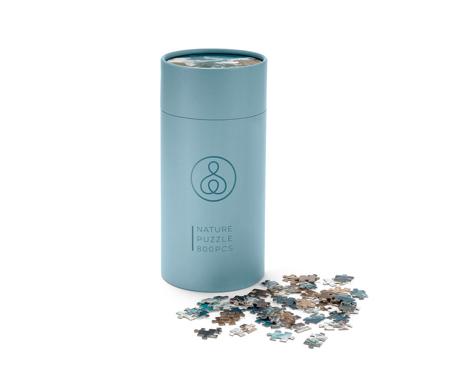 Yanında birkaç parça bulunan mavi bir Puzzle »Okyanus« tüpü.