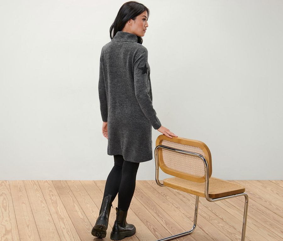 Kadın arkası dönük duruyor, Balıkçı Yaka Örgü Elbise giyiyor.