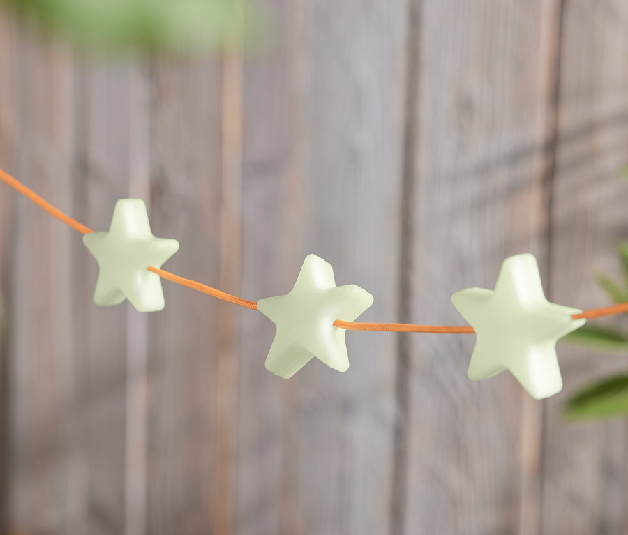 Turuncu bir ipe dizilmiş, yıldız şeklinde 8 adet gece ışıldayan işaret klipsi sırası.