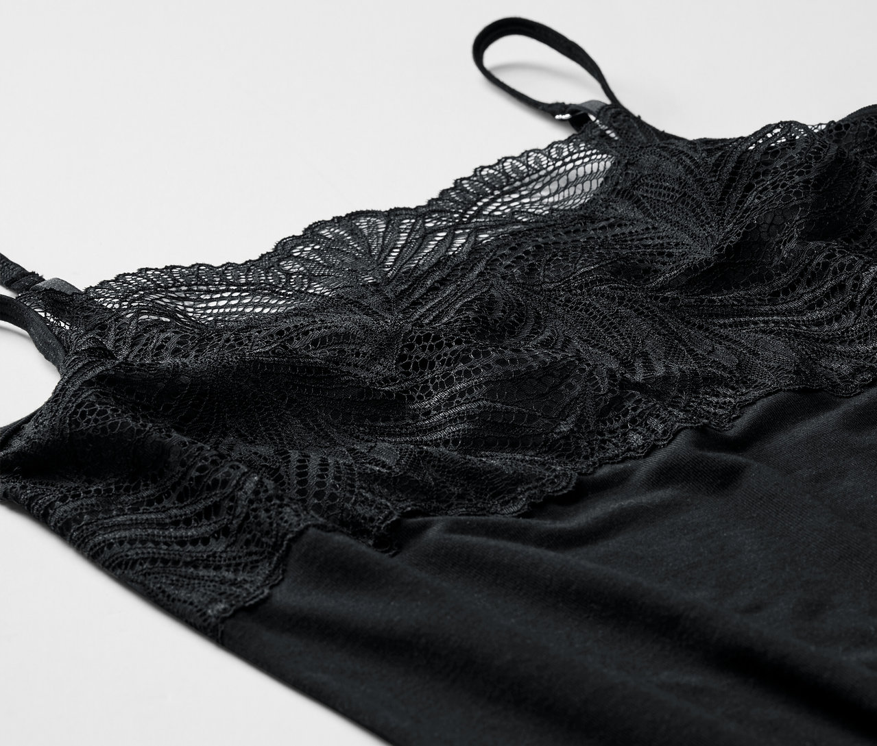 Beyaz bir arka plan üzerinde dantel detaylı siyah modal atlet.