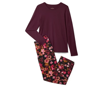 Bordo, uzun kollu üst ve çiçekli pijama altı beyaz bir zeminde duruyor.